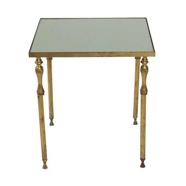 A beautiful, high-quality brass side table featuring a mirrored smoked glass top, created in the style of Maison Jansen...