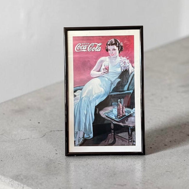 Vintage Coca Cola poster elegantly displayed in a vintage lacquered frame.