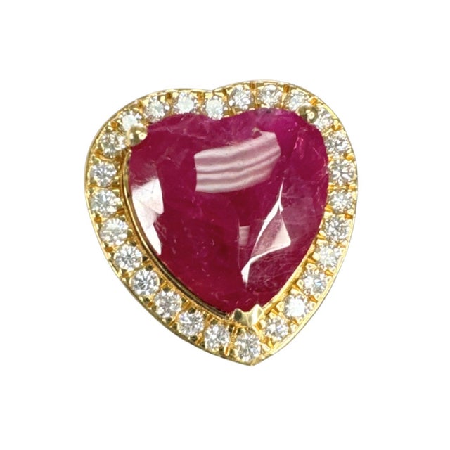 Centering an impressive 11.57 carat natural ruby, this striking cocktail ring features a bold heart-shaped mixed cut...