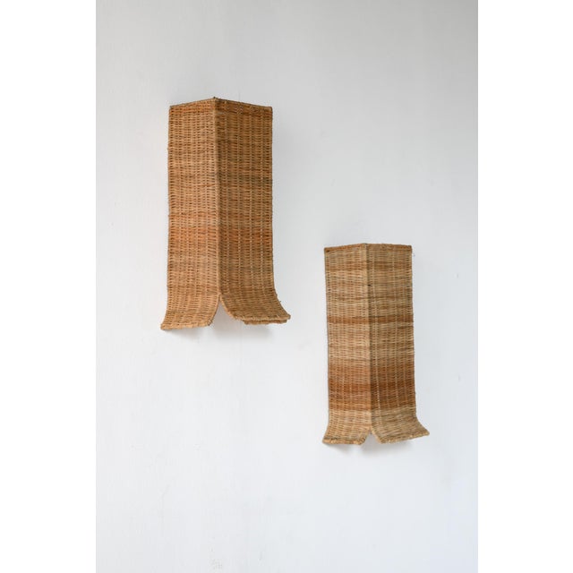 Embra wicker Wall light. This wall lamp wraps gentle light in the quiet poetry of woven wicker. Its vertically fluted form...