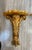 A pair of chic high style Hollywood Regency gilt and faux painted marble demi lune wall hanging tables. The acanthus leaf...