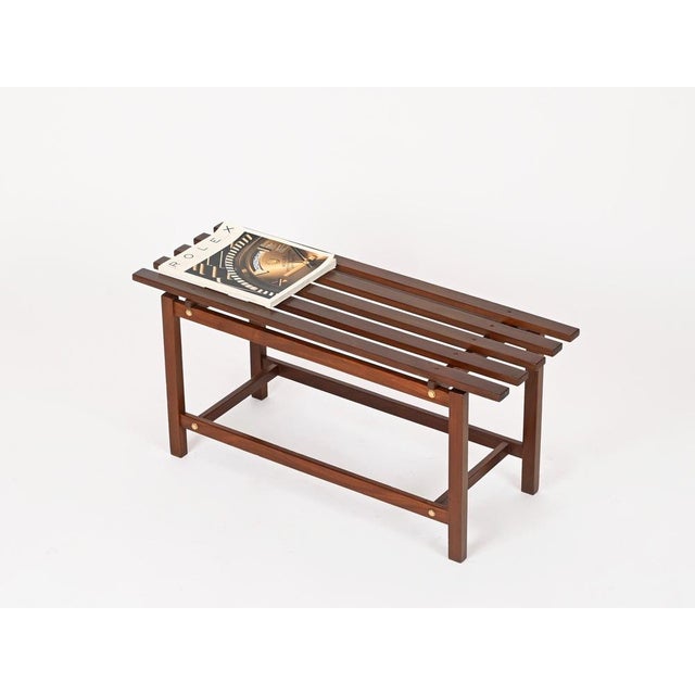 Wonderful and rare Mid-Century small bench in solid teak with elegant brass details. This stylish bench is attributed to...