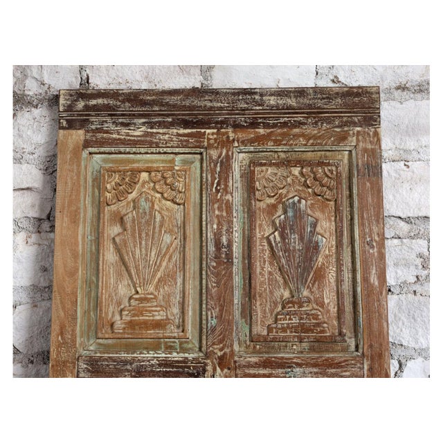 This striking antique carved wood door features a beautifully aged distressed green finish, revealing layers of history...