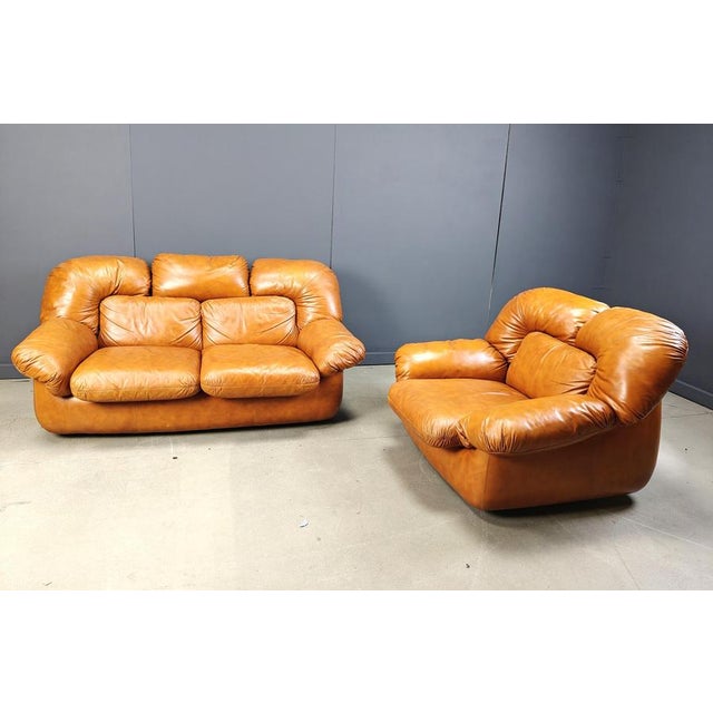 Mid century cognac leather sofa set consiting of a two seater sofa and armchair designed by Ercole Biella for Grappeggia....