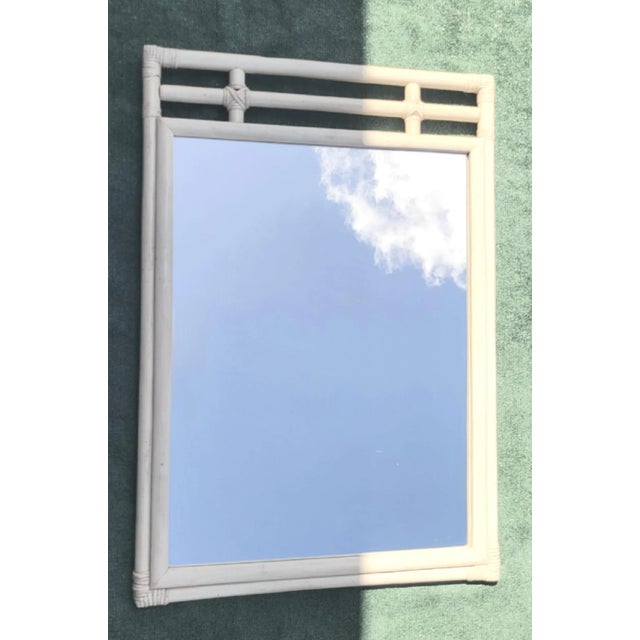 A vintage 1970's rattan off white Regency wall mirror. The mirror features simple lines in original off white color. This...