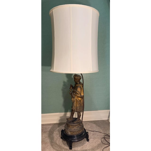 Vintage Figural Brass Lamp of robed nobelman on wooden stand.. Double medium base sockets with pull chains and thumb...