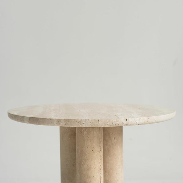 This travertine side table is crafted from solid stone and shaped with clean, angular lines. Its stacked form adds weight...
