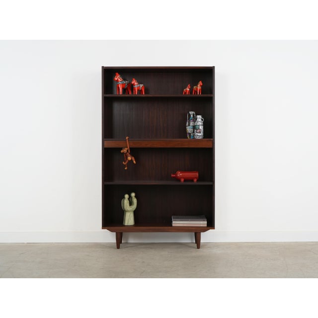 The bookcase was made in the 1970s, Danish production. The structure is covered with rosewood veneer. The legs are made of...