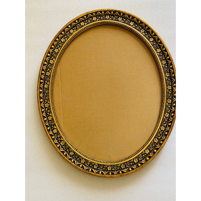 Vintage gold tone relief oval frame with glass or tray.
