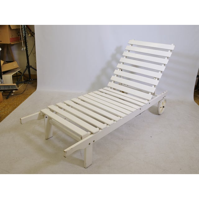 Triconfort's "Riviera" garden lounger on wheels features a wooden frame and a fabric reclining surface in a clean,...