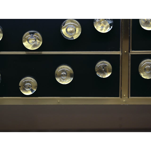 Discover the charm of Italian craftsmanship with this black glass sideboard. Made of solid birch wood and embellished with...