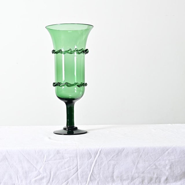 A French vintage 20th century handmade, emerald green footed vase. The cylindrical bowl of the vessel has straight, tall...