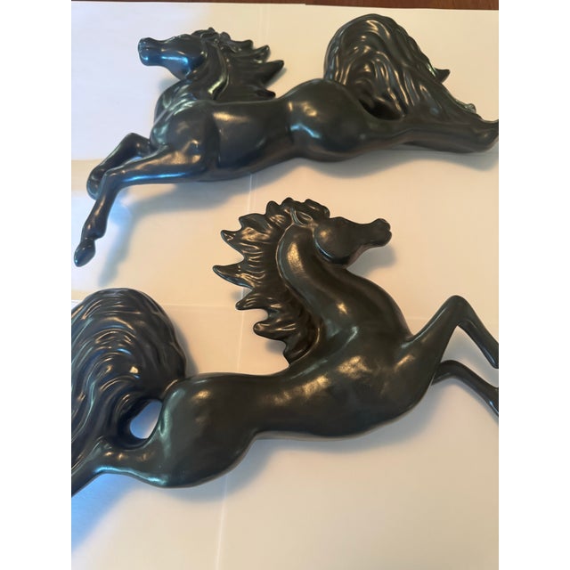 Mid-20th century set of two black vintage ceramic jumping horses sculptural wall art. Smooth matte black glaze. Rare and...