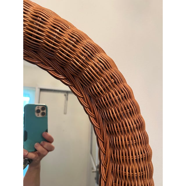 This is a vintage 1970s oval mirror with a woven rattan wicker frame. Stunning mid-century organic oval mirror completely...