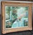 Design Plus Gallery presents a Still Life of a Dining Table on the Patio. The artwork has a signature that resembles...