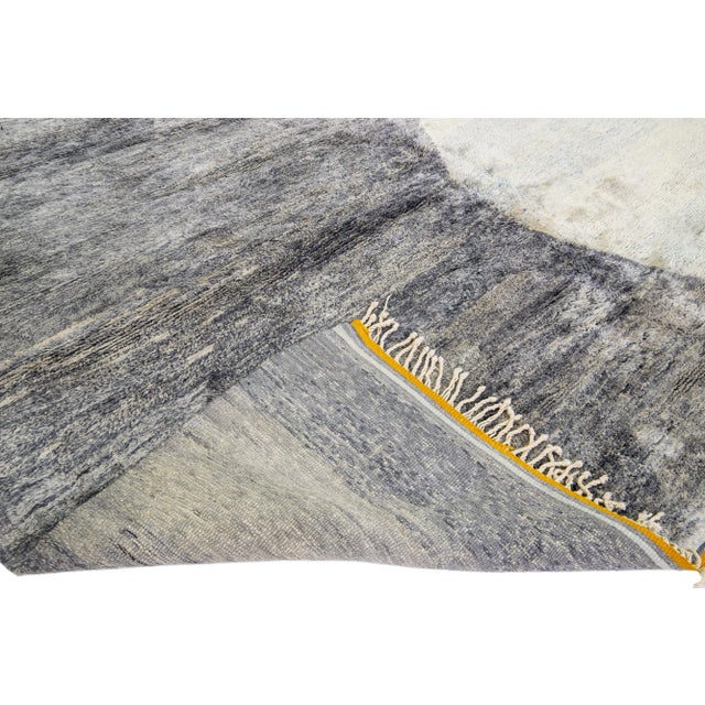 Beautiful Moroccan hand-knotted wool rug with a gray field. This Modern rug has yellow accent color and beige fringes in a...