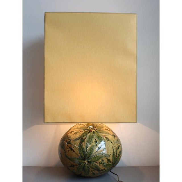 A bold and sculptural ceramic table lamp from the 1980s, featuring a high-gloss glaze and richly hand-painted botanical...