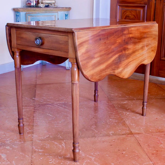 An unusually graceful American Sheraton Pembroke table of exceptionally finely figured mahogany. The leaves of serpentine...