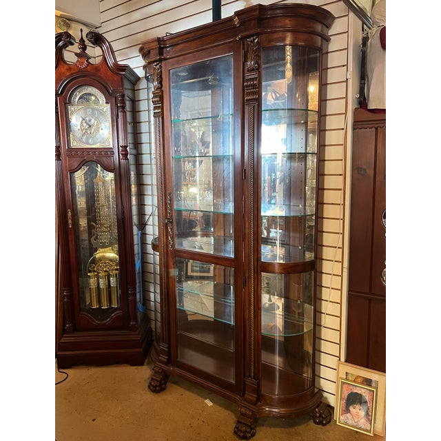 Beautiful dark wood display cabinet with curved side glass. The back of this tall curio cabinet sits flush against your...