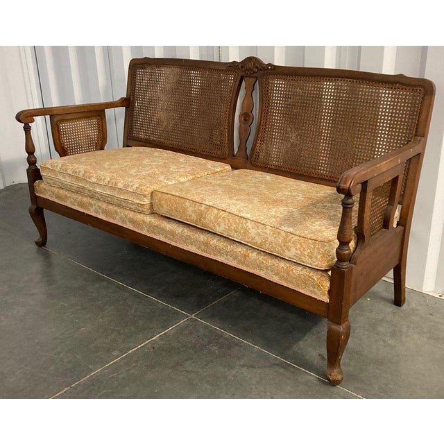Elegant cane settee with wood frame in original walnut finish. The fully-upholstered base as well as upholstered seat...