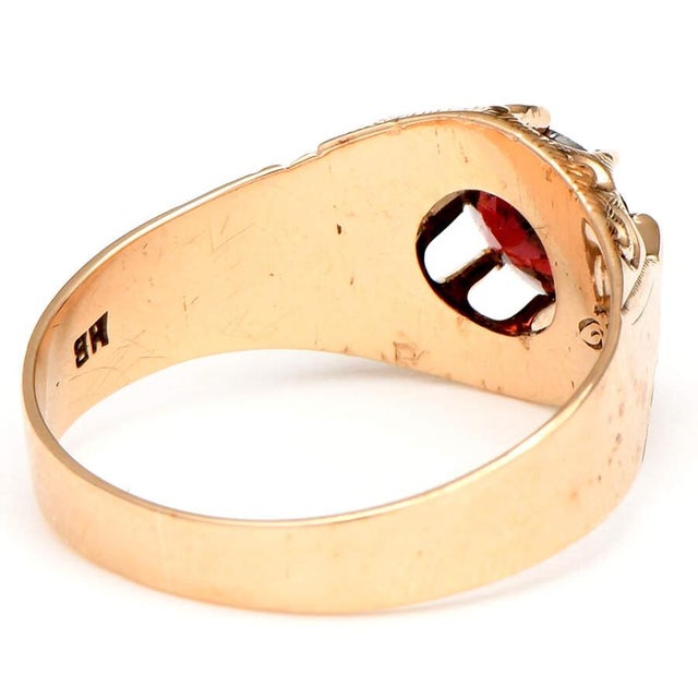 Detailed engravings form a magnificent setting for a beautiful garnet on this gold ring. The deep red garnet stands out...