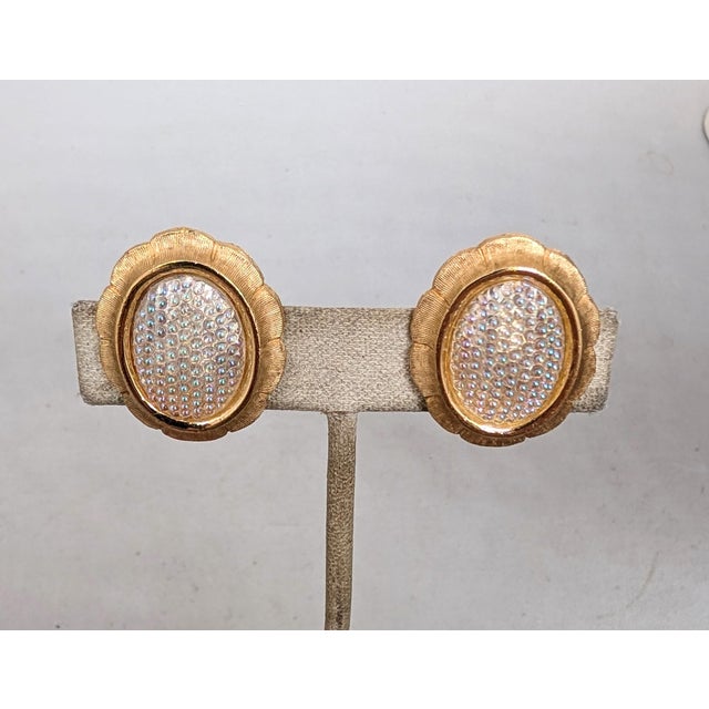 Rare goldtone oval domed bumpy iridescent white with hints of pink, green, yellow & blue depending on the light rhinestone...