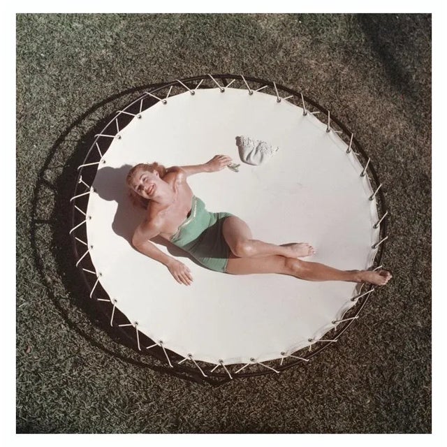 Esther Williams 1956 American swimmer and actress Esther Williams (1921 – 2013) lounging on a trampoline, circa 1956. Slim...