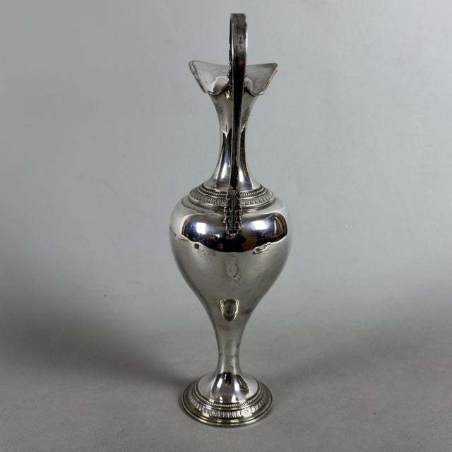 A piece of silverware of rare finesse and timeless charm. This splendid amphora-shaped pourer represents an excellent...