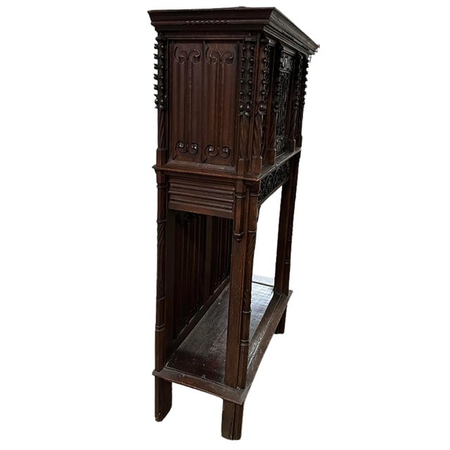 A handsome 19th Century two-piece gothic style oak cabinet. Beautifully carved and finished grapevines along the top and...