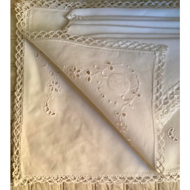 A set of 6 white fine linen placemats with white embroidery on the corners, white lace trim all around the border & a set...