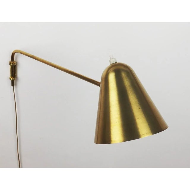 Adjustable brass wall lamp created by Jacques Biny in the 1950s for Luminalite. Can form a set with a double lamp that we...