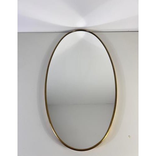 This elegant Italian oval wall mirror from the 1960s embodies the refined simplicity and timeless sophistication of mid-...