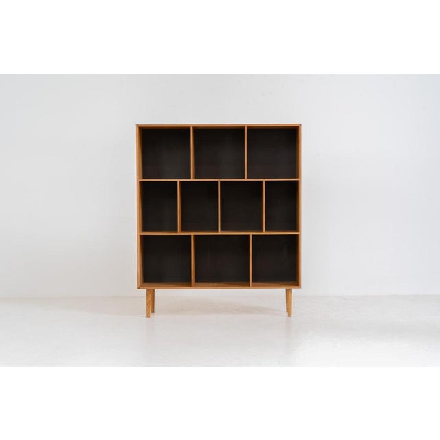 Oak bookcase by Kurt Østervig (Denmark, 1960s). A minimalistic bookcase crated in oak with vertical adjustable shelves and...
