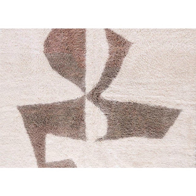 Refined hand-knotted wool rug in soft Ivory, featuring abstract shapes in Deep Taupe and Light Taupe. The modern yet...