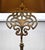 Sturdy table lamp with intricate ornamentation. Polished brass. Fabric shade with inner gold foil. Condition: fully...