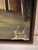 A Haitian village river scene in oil, signed and dated by the artist. The composition centers on a dugout canoe with two...