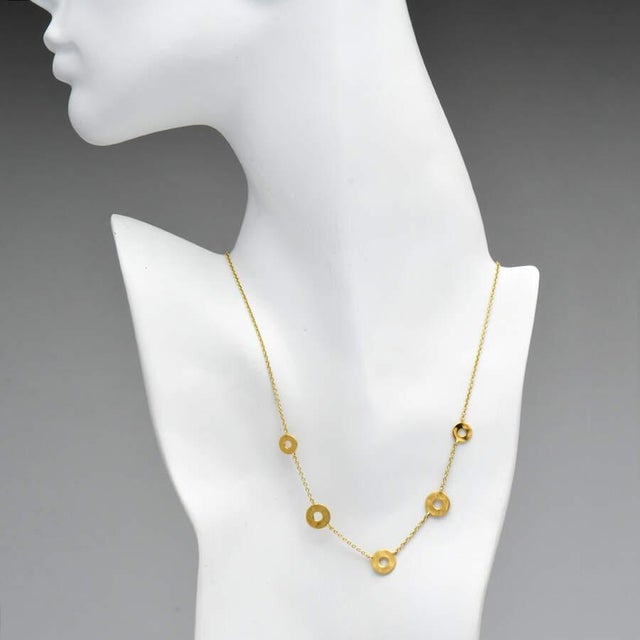 Clean and simple, the disks on this yellow gold necklace invite you to embrace minimalism and appreciate the gold's...