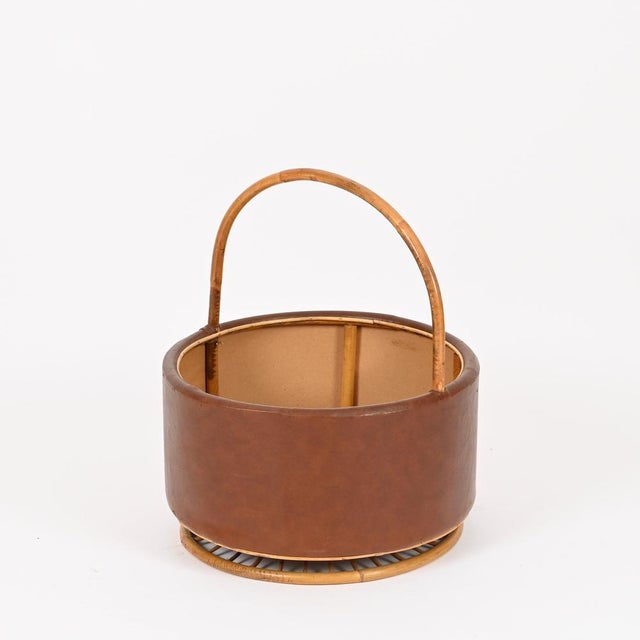 Wonderful and unique large decorative basket in curved rattan and brown leatherette. This stylish organic basket was...