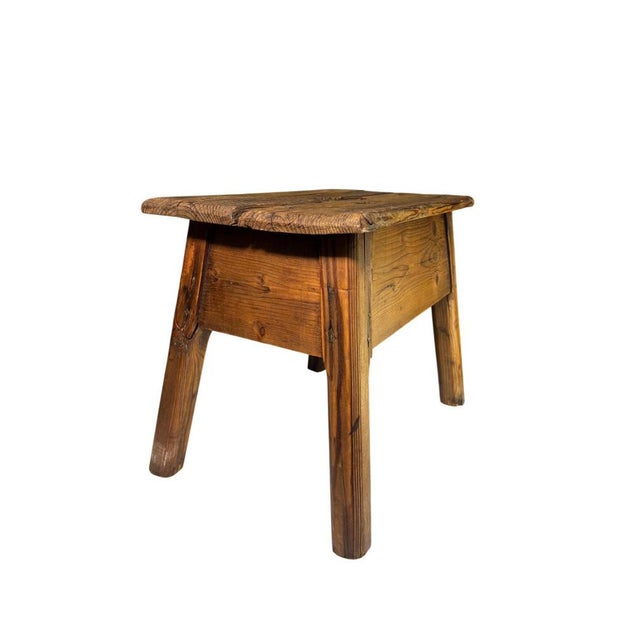 Wooden milking stool, featuring a solid structure and a natural finish that highlights its grain. It can be used as a...