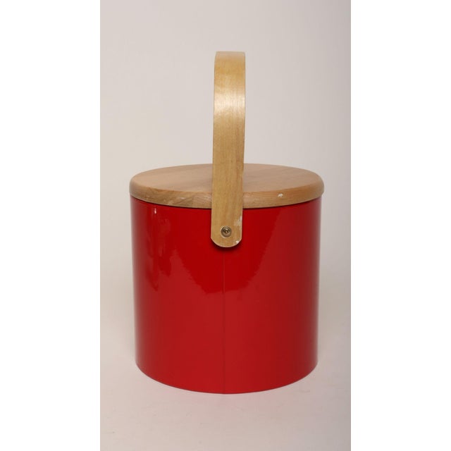 Stylish ice bucket in red patent vinyl with solid birchwood lid and sculptural handle and white plastic insulated interior...