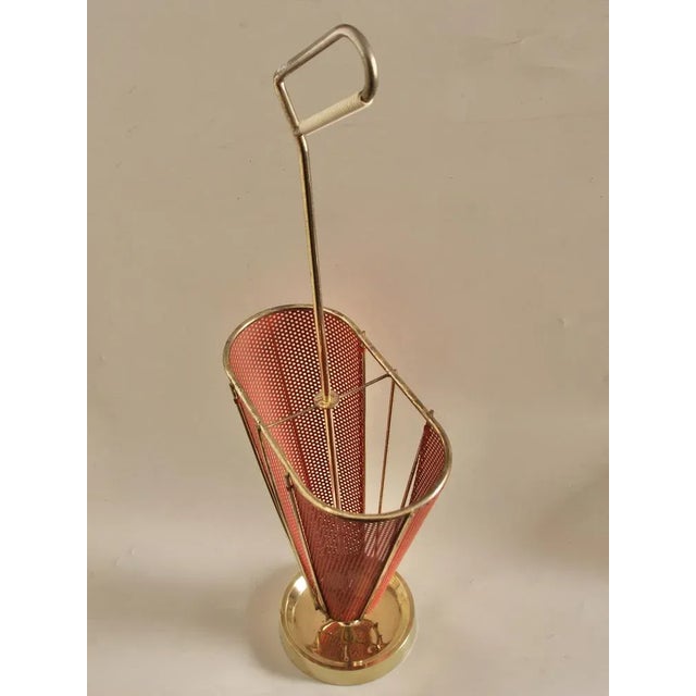 Very fancy umbrella stand in the form of a half open screen. The design with the red perforated plate is reminiscent of...