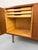 Small teak sideboard with two lockable hinged doors and three shallow drawers on the left and two shelves on the right....