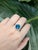 This striking ring features a vibrant 4.25-carat London Blue Topaz, sourced from Brazil and treated with irradiation to...