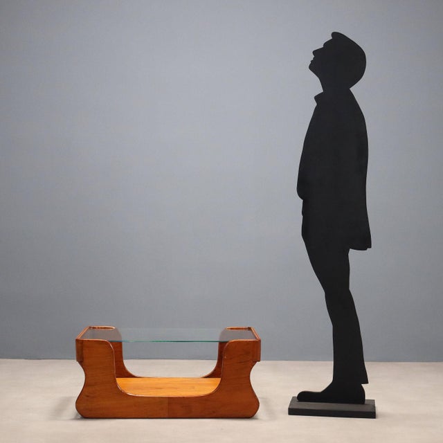 Double-top coffee table in teak veneer and glass. This piece is attributed to the mentioned designer/maker. It has no...