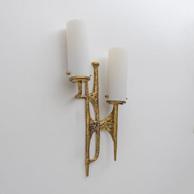 Pair of Brutalist cast bronze wall lamp, made in the Maison Arlus style, in the manner of Felix Agostini. This wall lamp...