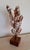 This striking accent piece showcases an array of natural seashells elegantly suspended on wire mounts atop a wooden base....