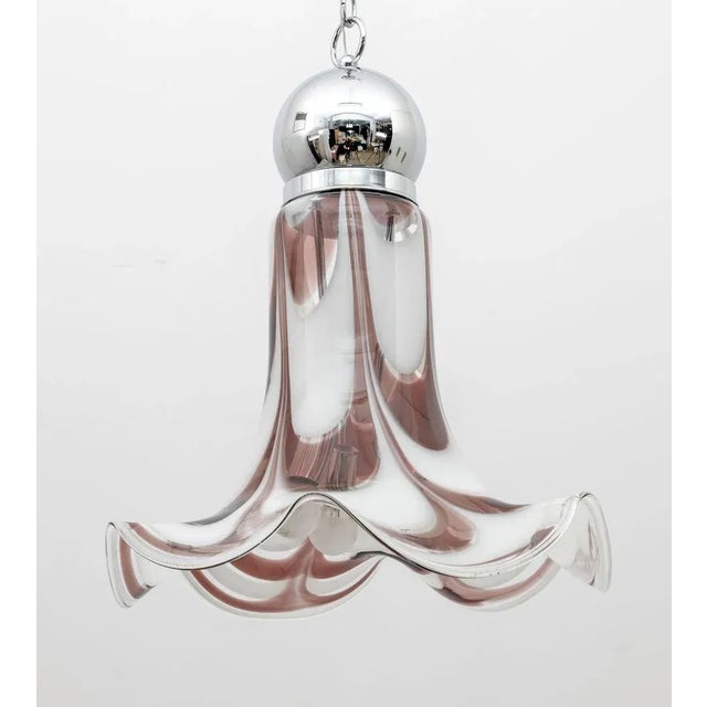 This ceiling light is characterized by a bell-shaped lampshade in white and brick red Murano glass and chromed metal,...