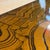 This is a large postmodern brass and lacquer coffee table. The tabletop has a stunning woodgrain like lacquer finish that...