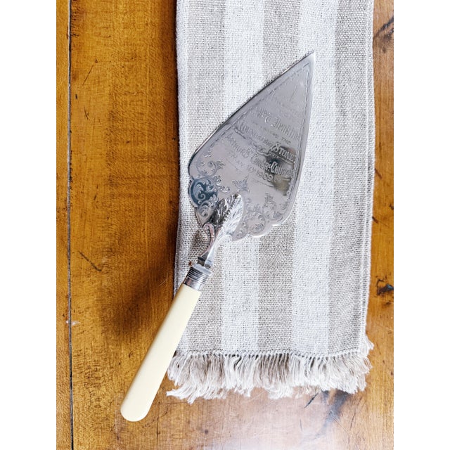 A beautiful antique circa 1909 English silver plated trowel with celluloid handle, awarded for the laying of a corner...