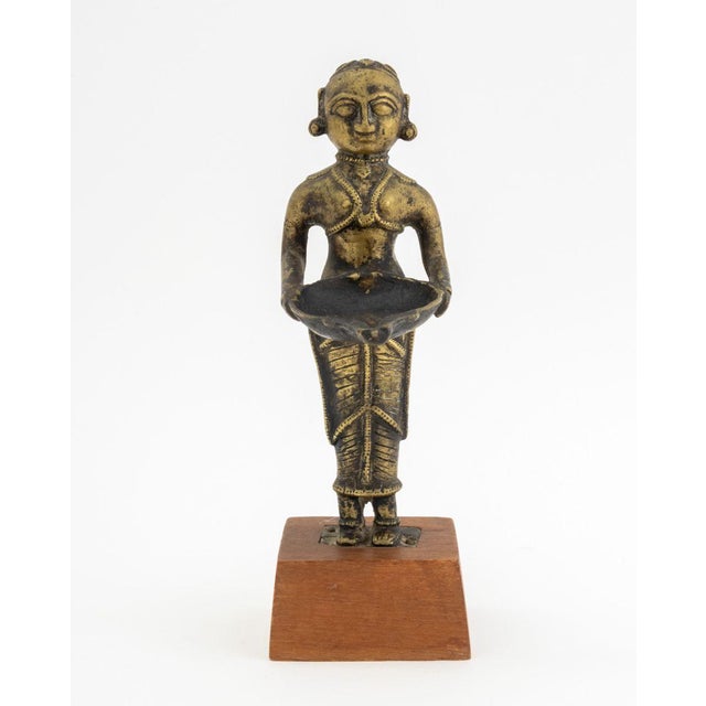 Indian Brass Deeplakshmi Figural Oil Lamp, mounted on wood base. Overall: 9.25" H x 4.5" W x 3" D. Provenance: From a 860...
